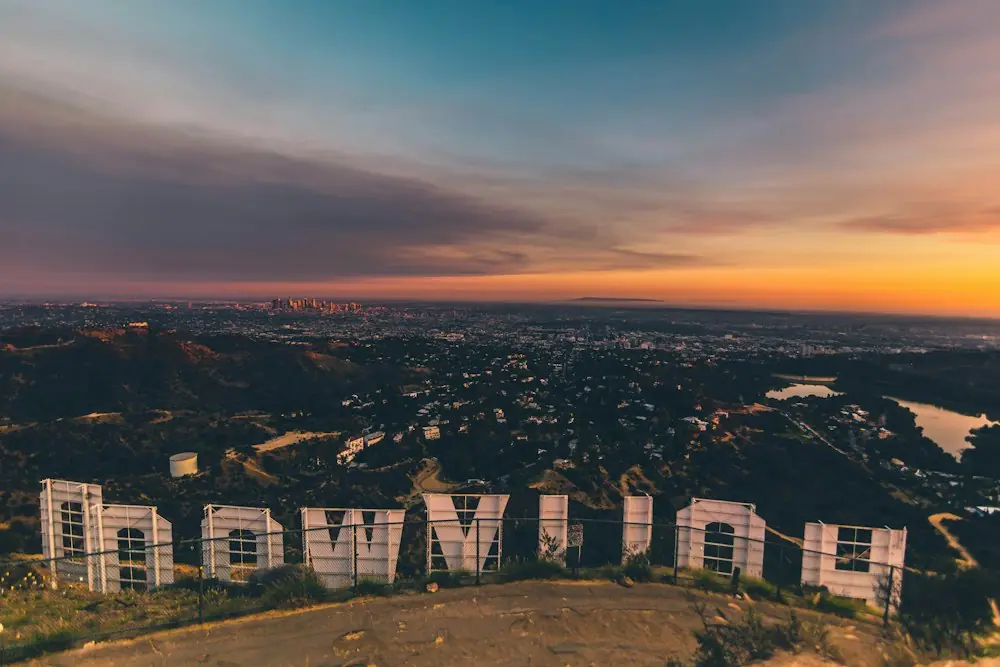 Skyline van Los Angeles bij zonsondergang met palmbomen