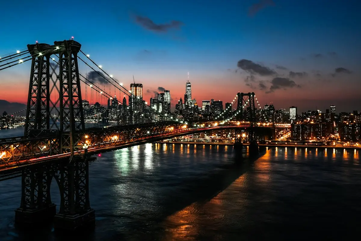 Williamsburg Bridge en de skyline van Manhattan bij schemering