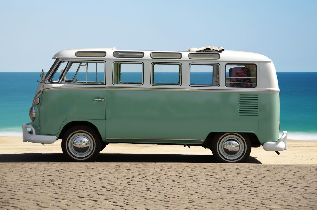 Klassiek groen campervan geparkeerd aan het strand