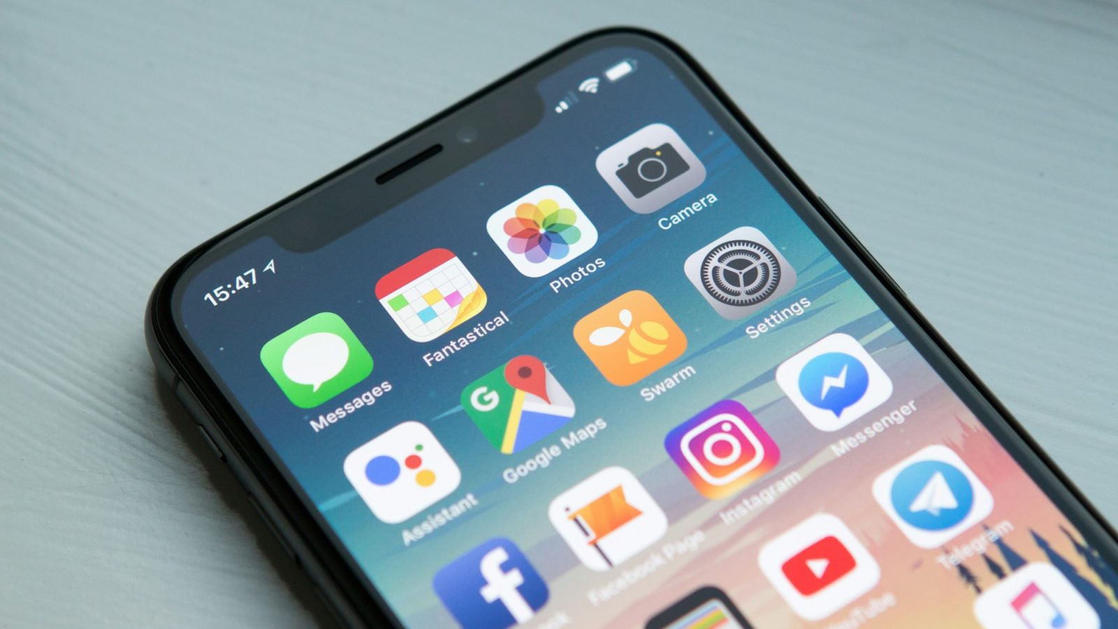 Smartphone met apps op het scherm op een houten tafel