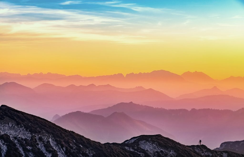 Bergketens in roze en oranje avondlicht